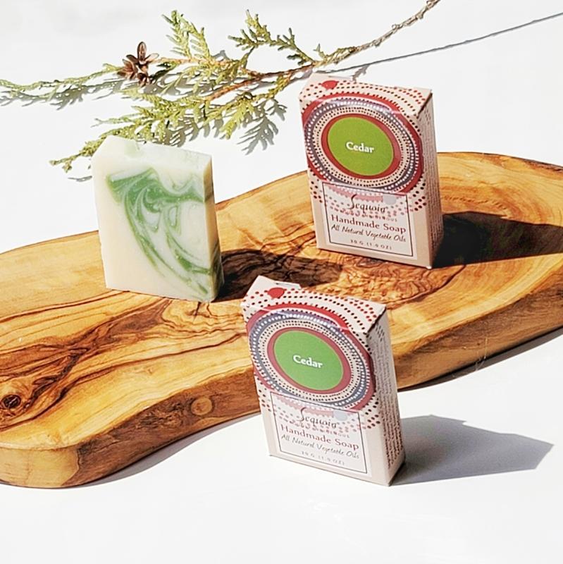 Two boxes of handmade soap with a green label on a wooden board.
