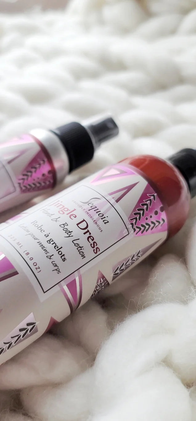 Two bottles of 'Magic Dress' body lotion on a textured white surface
