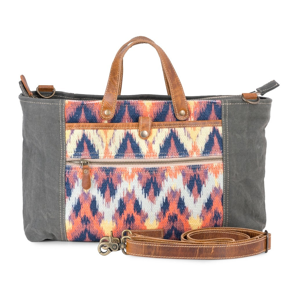 Handbag with gray body and colorful patterned flap on a white background