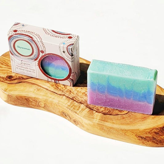 Colorful soap bar on a wooden tray with a branded box in the background