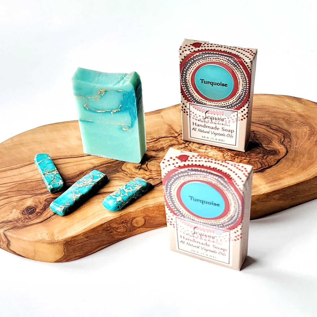 Turquoise soap bars with packaging on a wooden board