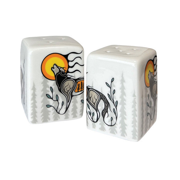 Two ceramic dice-shaped salt and pepper shakers with wolf designs on a white background
